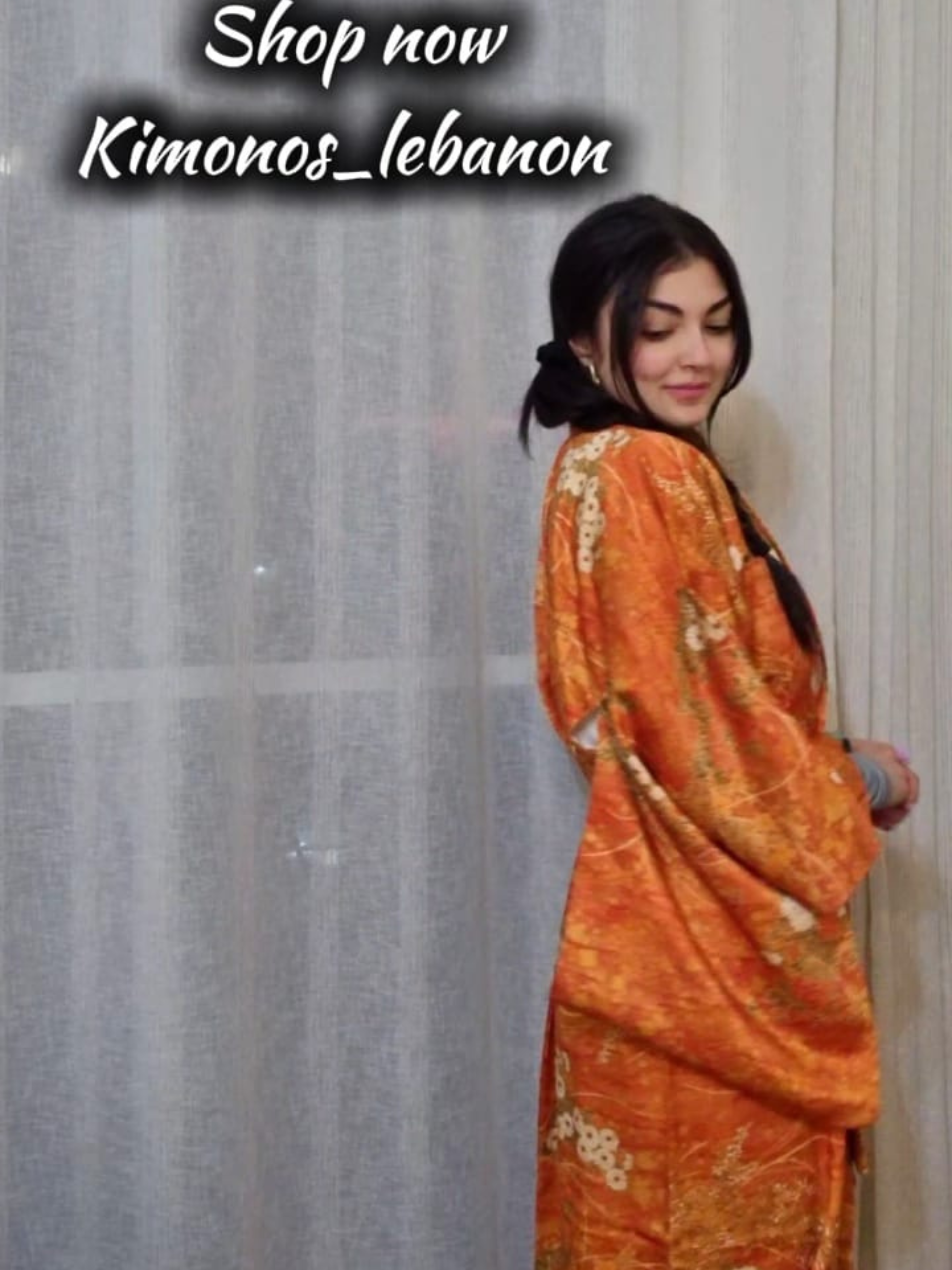 Woman wearing an orange kimono-style outfit with text promoting 'Kimonos_lebanon' brand.