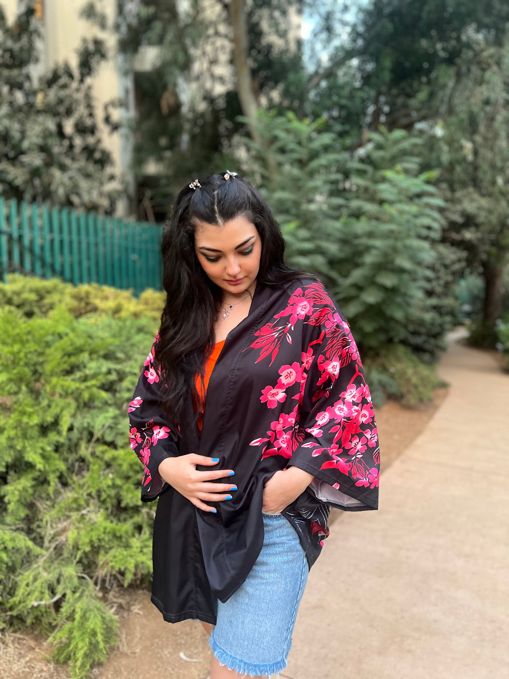 Woman wearing a black floral kimono in a garden setting