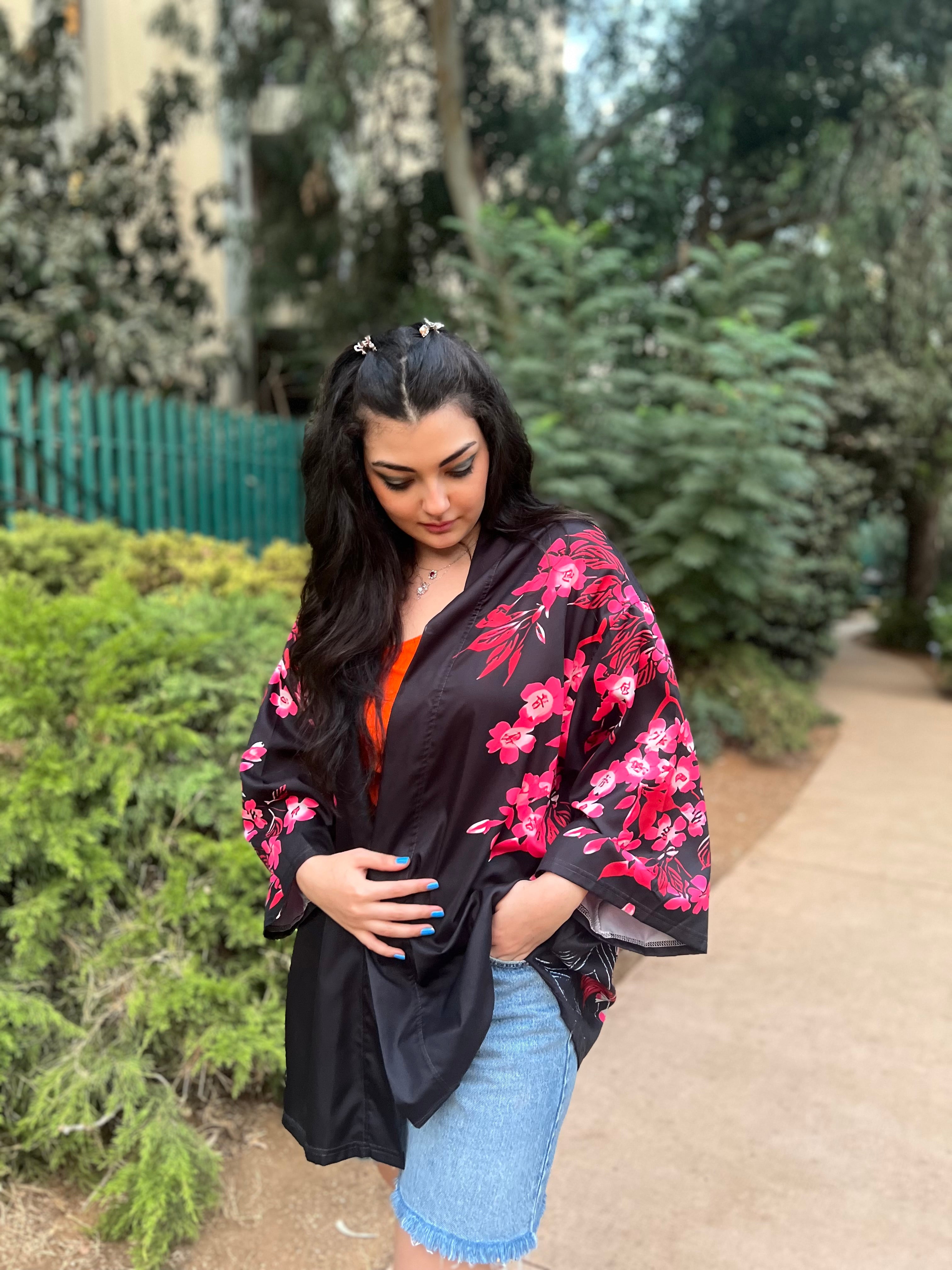 Woman wearing a black floral kimono in a garden setting