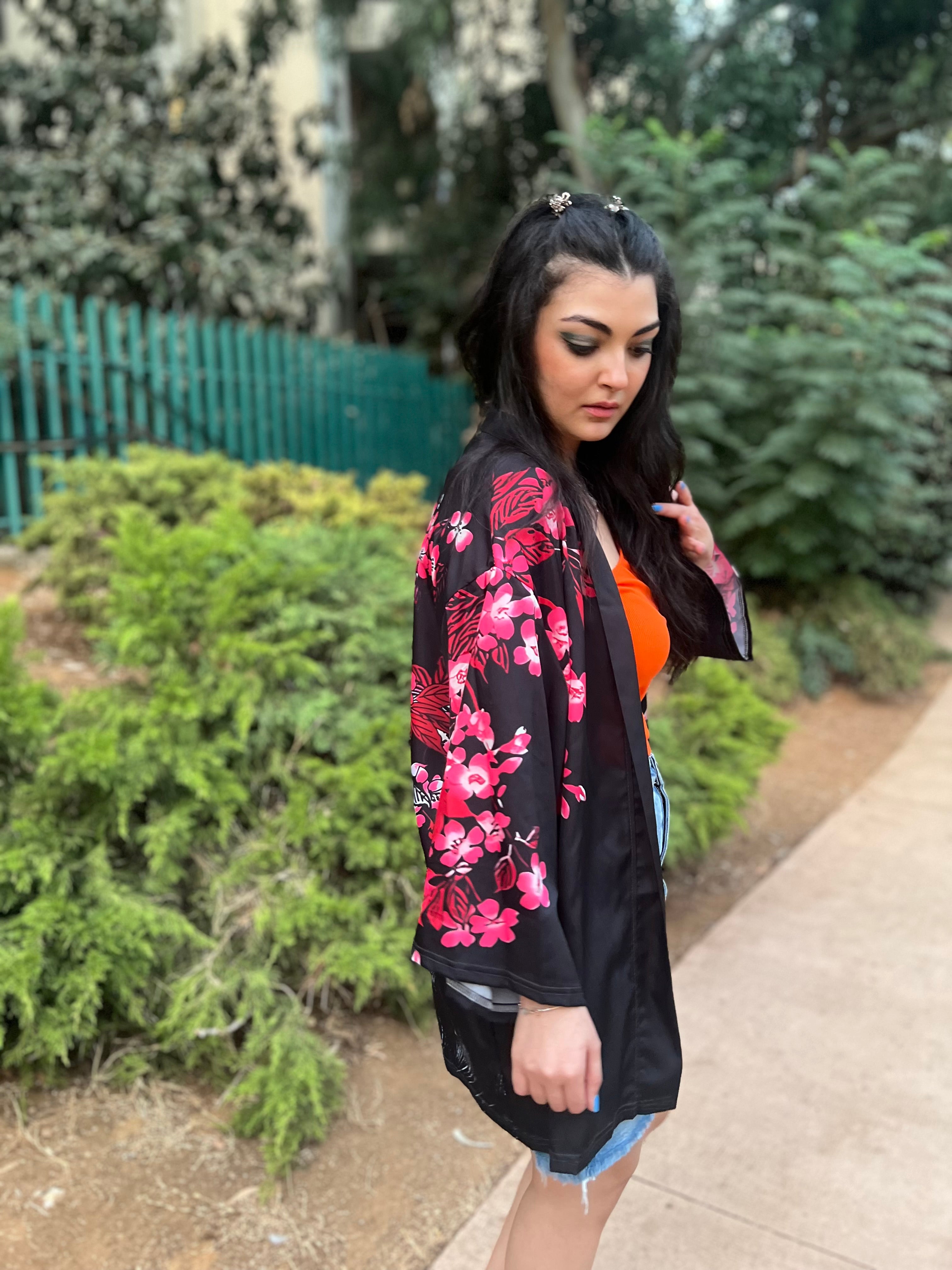 Woman wearing a black floral kimono in an outdoor setting