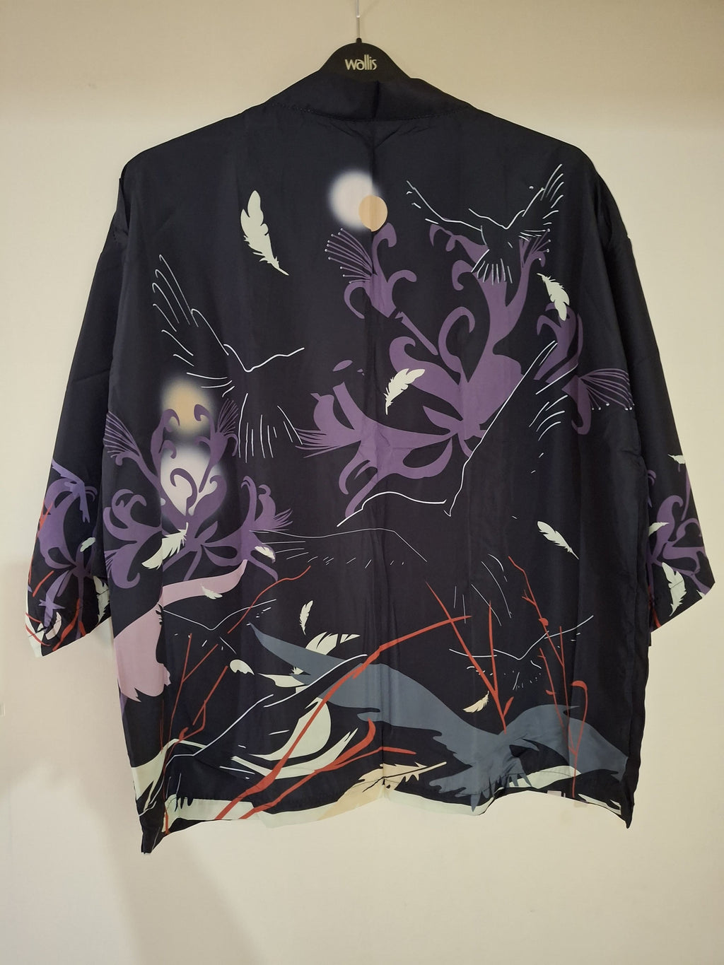 Black kimono with colorful abstract designs on a beige background