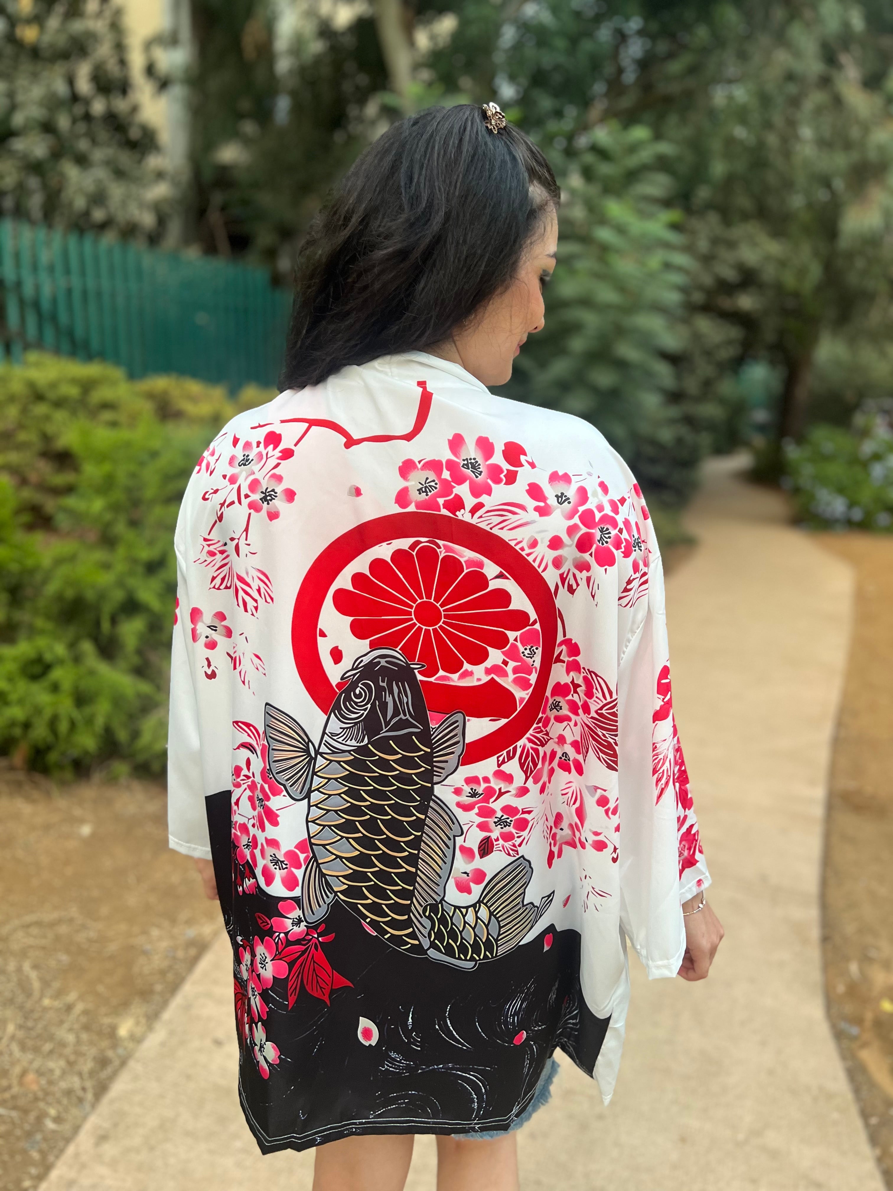 Woman wearing a kimono with a fish design in a garden setting
